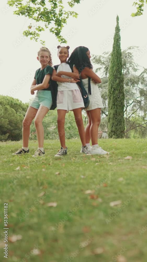 VERTICAL VIDEO: Smiling three girls friends pre-teenage cross their arms in dance move in the park VERTICAL VIDEO: Smiling three girls friends pre-teenage cross their arms in dance move in the park