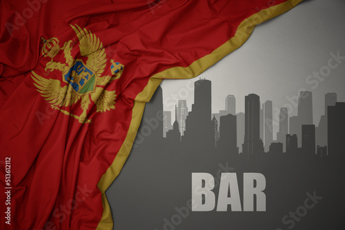 abstract silhouette of the city with text Bar near waving national flag of montenegro on a gray background.