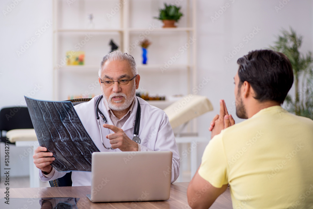 Young male doctor visiting old male doctor radiologist Young male doctor visiting old male doctor radiologist