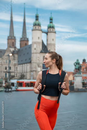 Wallpaper Mural Athletic beautiful woman in fitness clothes, walks along the square of the old European city Torontodigital.ca
