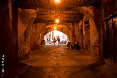 Three people come out of the dark street  rue obscure  in villefranche sur mer on the french riviera