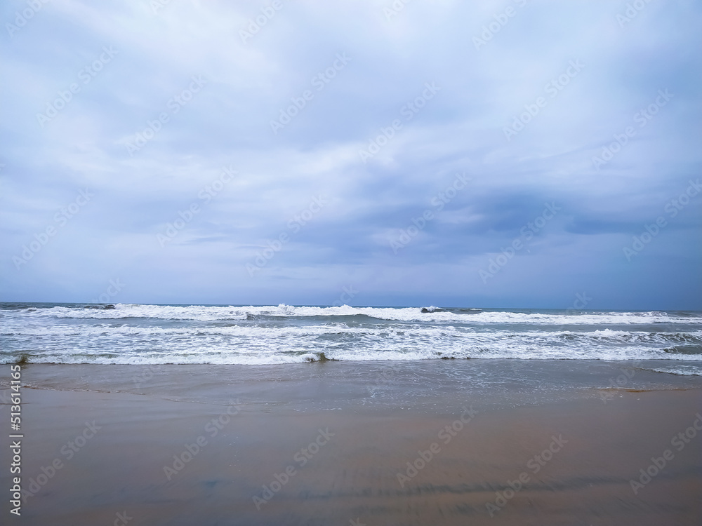 Soft wave of sea on the sand beach with cloudy sky