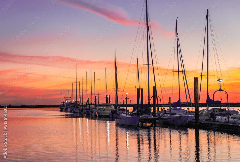 Large yacht harbor in colorful bright sunset light, luxury summer cruise, sailboats in summer sunset.