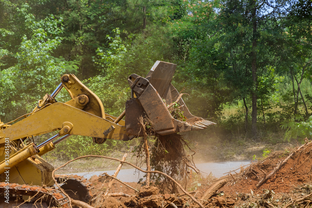 Fototapeta premium Land cleared from roots for housing development subdivision using tractors skid steers