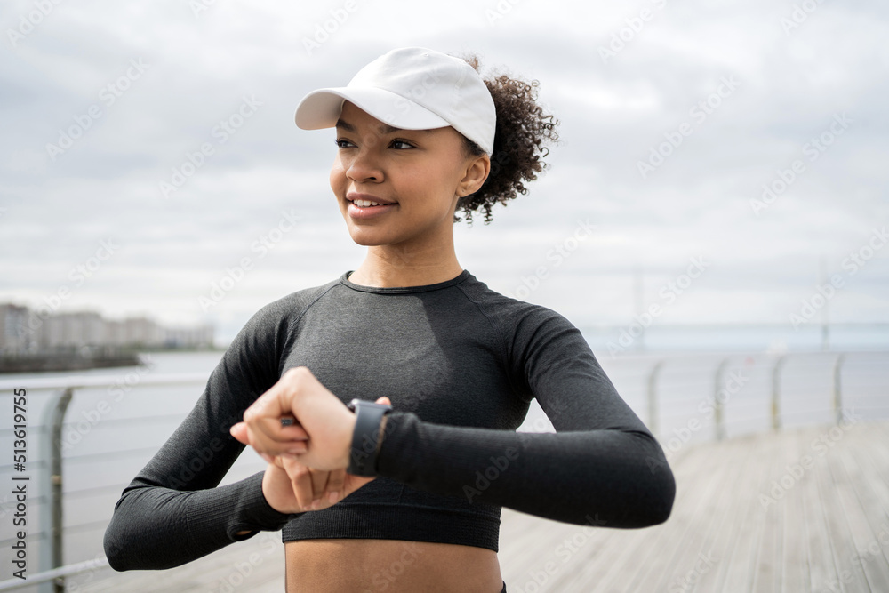 Fitness watch on the arm, pulse and calories. Woman training on the street, active exercises in a sports uniform