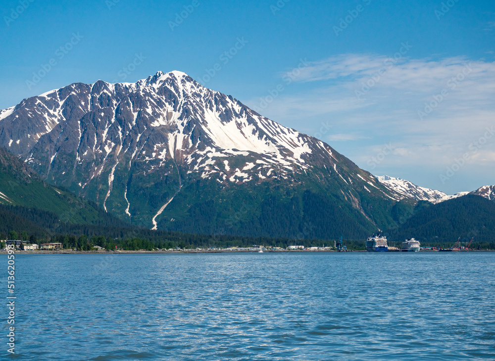 Snow covered peak of the mountain overlooking the port of Seward in Alaska with cruise ships