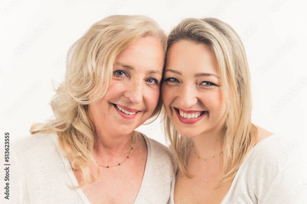 Close-up studio shot on white background of two middle-aged caucasian cheerful women with blue eyes looking directly at camera. High quality photo Close-up studio shot on white background of two middle-aged caucasian cheerful women with blue eyes looking directly at camera. High quality photo