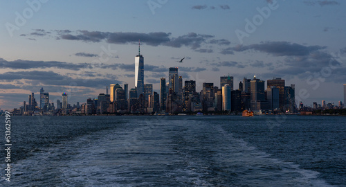 Lower Manhattan skyline at sunset viewed from the water.