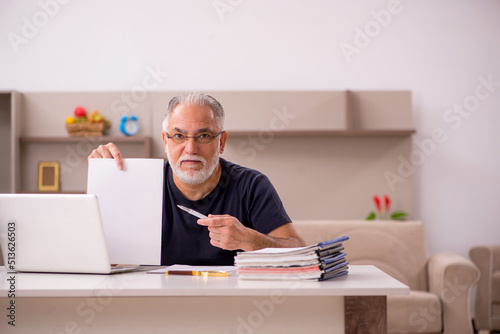 Old male employee working from home during pandemic