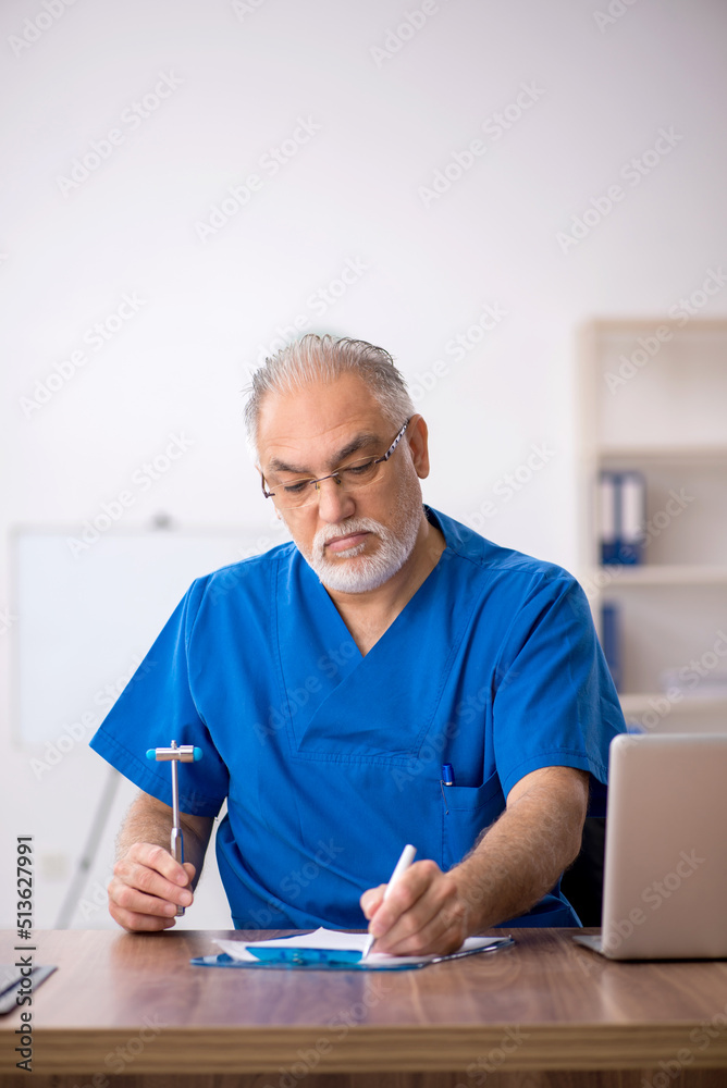 Old male doctor working in the clinic Old male doctor working in the clinic