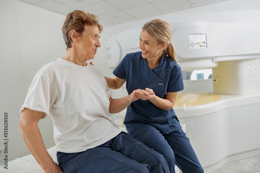 Radiologist help to patient sit after procedure of MRI or CT Scan . High Tech medical equipment Radiologist help to patient sit after procedure of MRI or CT Scan . High Tech medical equipment