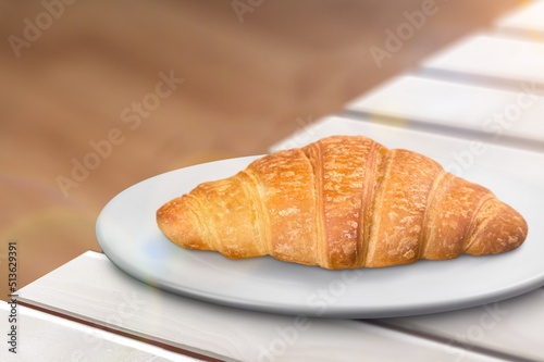 Croissant on a white plate, freshly baked.