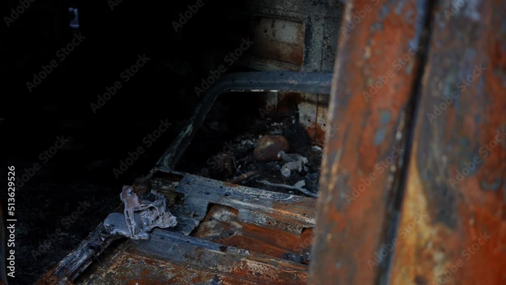 Bombed burnt car interior close-up with live camera moving left and right. Ruined destroyed automobile leftovers outdoors in Kyiv suburb in Ukraine. Slow motion Bombed burnt car interior close-up with live camera moving left and right. Ruined destroyed automobile leftovers outdoors in Kyiv suburb in Ukraine. Slow motion