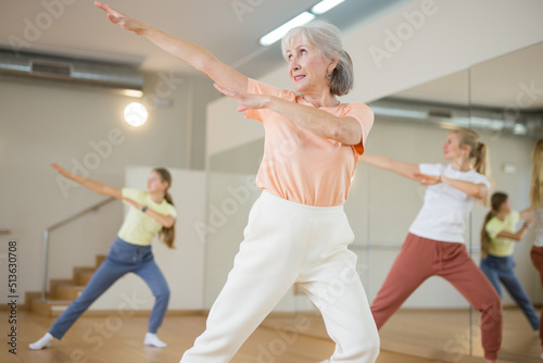 Sticker Portrait of cheerful active female pensioner exercising dance moves in fitness s