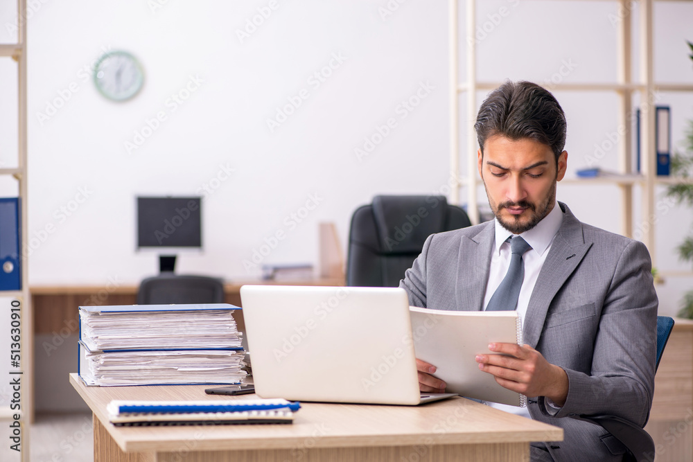 Young male employee working in the office Young male employee working in the office