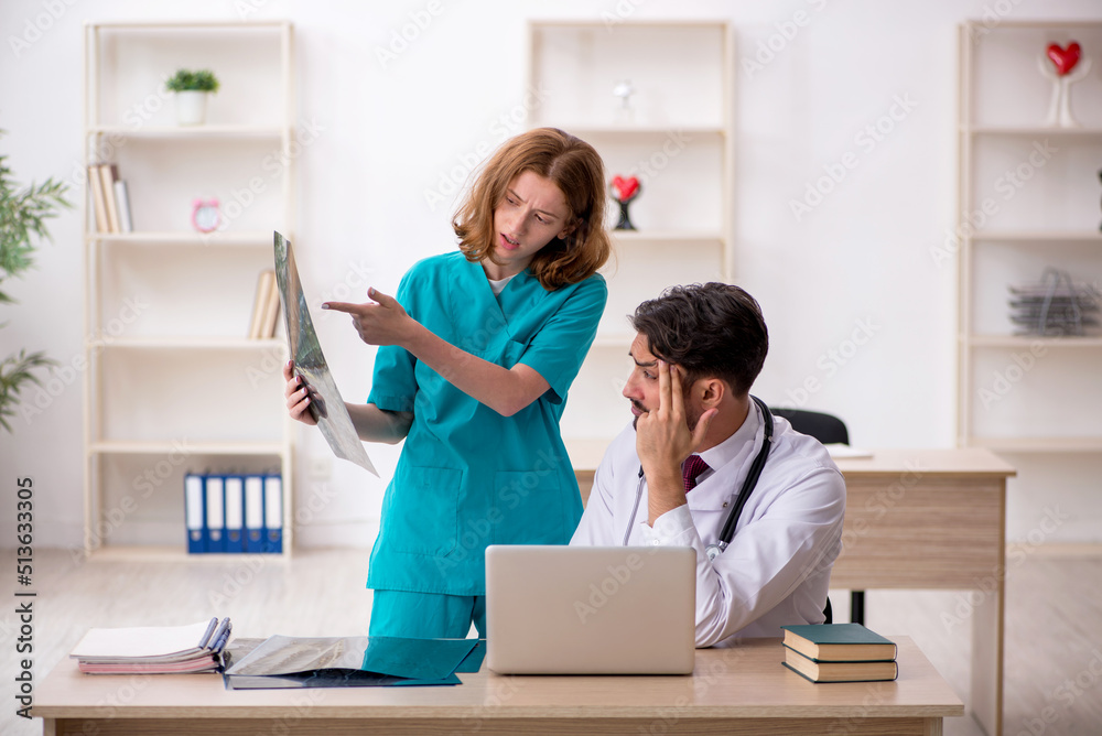 Young male doctor radiologist and female assistant working in th Young male doctor radiologist and female assistant working in th