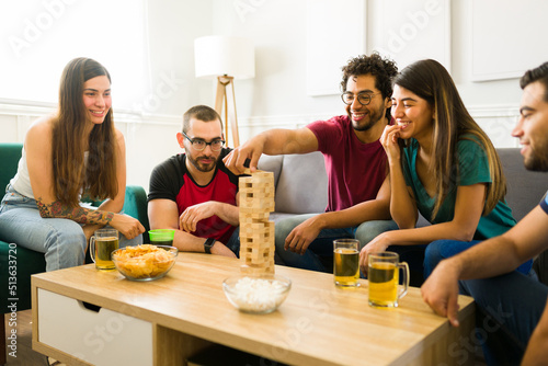 Canvas Print Attractive friends enjoying a fun time together while playing board games