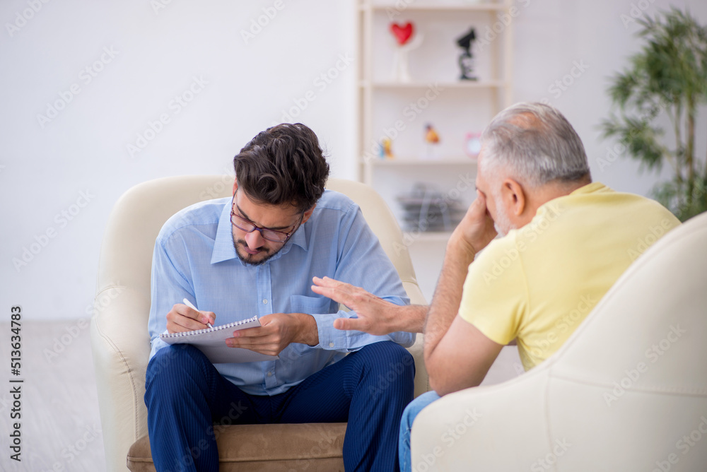 Old man visiting young male psychotherapist Old man visiting young male psychotherapist