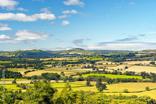 Southwest from Wenlock Edge near Easthope over summer farmland of Ape Dale to Caer Cardoc and The Long Mynd, Shropshire, England photo