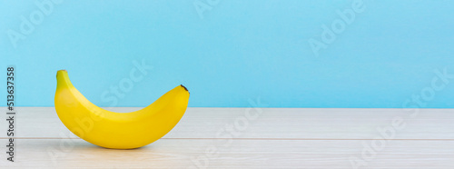 A banana on the table. light blue background. テーブルの上のバナナ。 水色背景