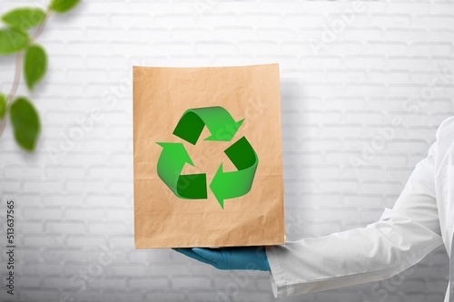 Girl holding paper bag with old clothes for recycling concept.