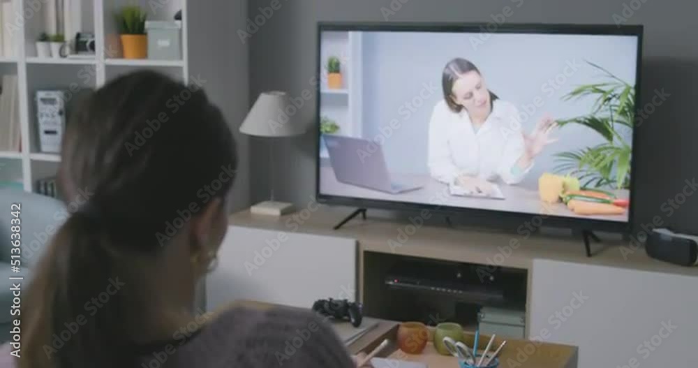 Woman watching a nutritionist talking about healthy diets Woman watching a nutritionist talking about healthy diets