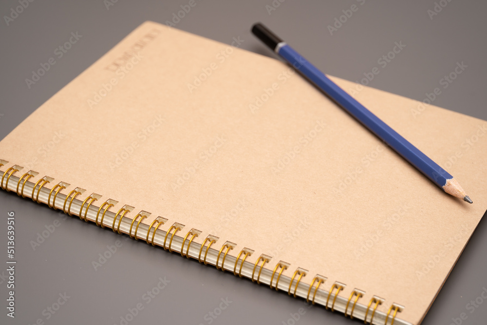 closed spiral blank craft paper cover notebook with pencil. Office and study items close-up. Flat lay closed spiral blank craft paper cover notebook with pencil. Office and study items close-up. Flat lay