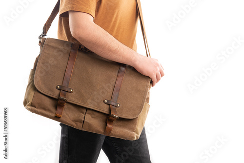 Brown suede shoulder bag, yellow T-shirt and white background jeans carry laptop and documents on a man's shoulders. Satchel, male suede handmade briefcase.