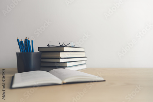 Open book and stack of textbook on table. Business success idea of learning, planning or working. Education concept of studying and knowledge cognition. Businessperson or student training skill photo
