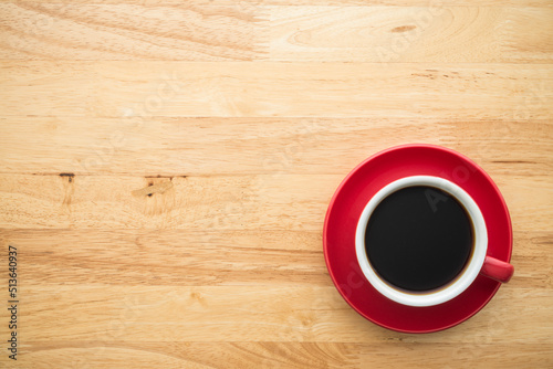 Top view of red drip coffee cup on wooden table background with copy space minimal style. Simple drinking coffee slow life concept.
