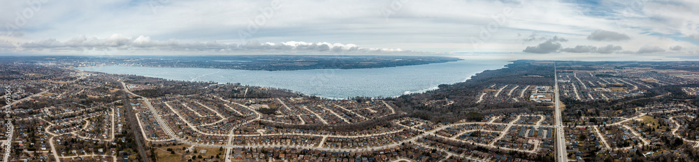 centennial park barrie panorama frozen lake  with houses and clouds in the sky 