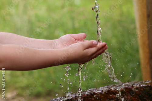 Kind fängt Wasser mit beiden Händen auf