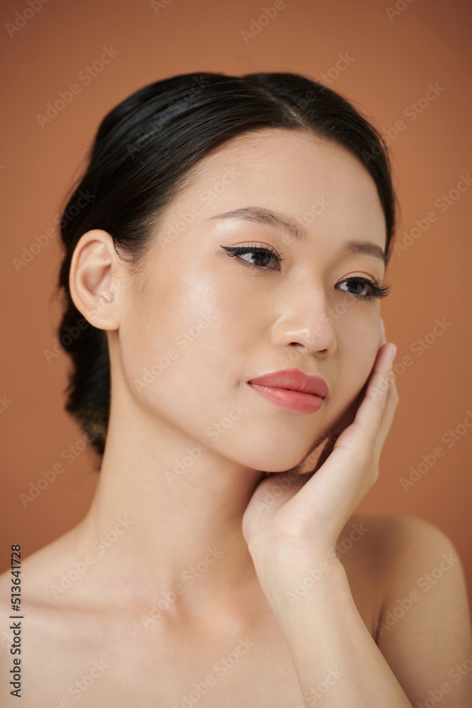 Portrait of Asian pensive young woman and touching her soft skin Portrait of Asian pensive young woman and touching her soft skin