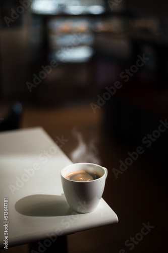 hot coffee on a table with cream being poured into it showing the texture