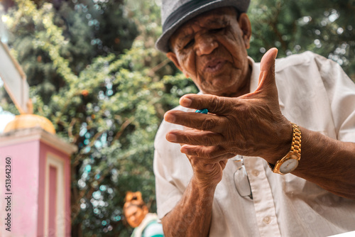 Latino elderly man writing down on his hand with a pen in an outdoor park in Jinotega photo