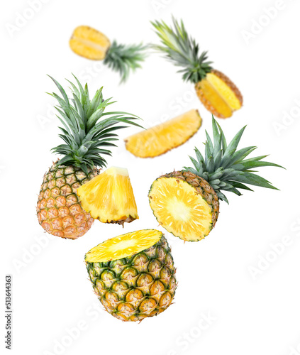 Pineapple with cut slices flying in the air isolated on white background.
