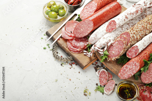 Fotografija Sausages salami assortment on light background.