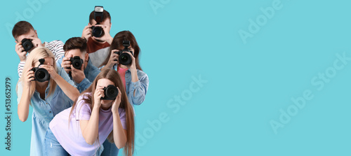 Group of young photographers on blue background photo