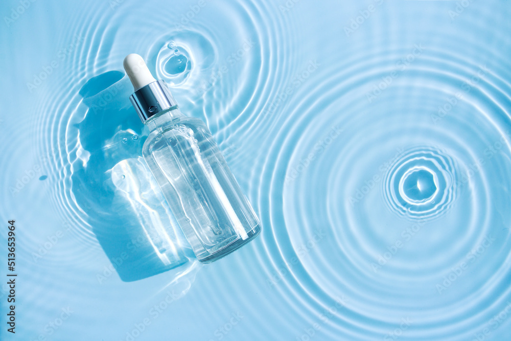 bottle of serum in clean clear water with splashes and waves bottle of serum in clean clear water with splashes and waves