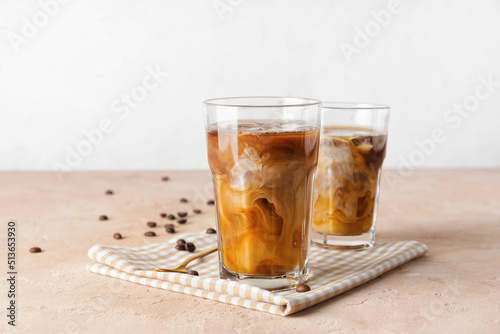 Tablou pe pânză Glasses of cold brew coffee on beige table against light background