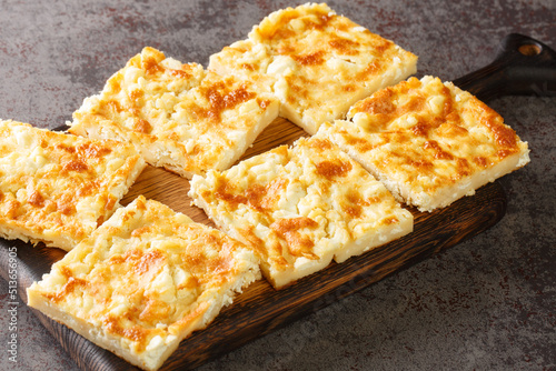 Alevropita crispy feta pie is a specialty of Epirus close-up on a wooden board on the table. Horizontal
