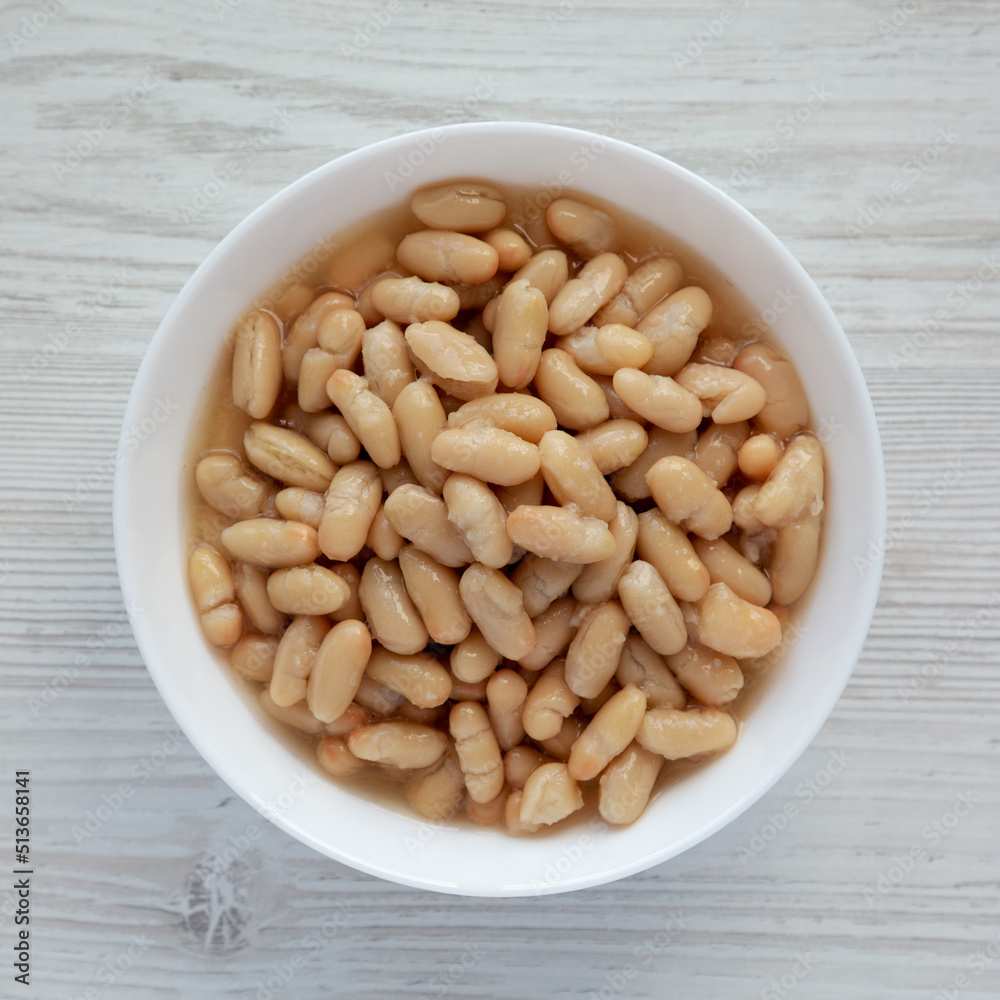 Organic White Cannellini Beans in a White Bowl, top view. Flat lay, overhead, from above. Organic White Cannellini Beans in a White Bowl, top view. Flat lay, overhead, from above.