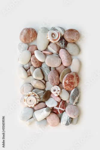 Aesthetic minimal pattern with set of sea pebble stones on white background. Square composition from natural round smooth stone pink grey color. Collection of rocks, summer concept, top view