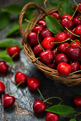 Ripe cherries, berries in a wicker basket with water drops. Vintage style