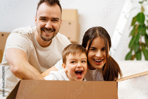 Parents and son packing boxes and moving into a new home © fotofabrika