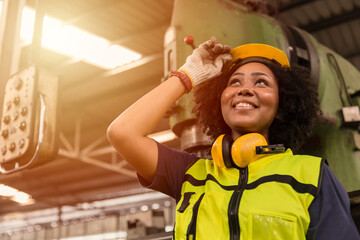 American black women teen worker enjoy working labor in industry factory with heavy steel machine happy smiling.