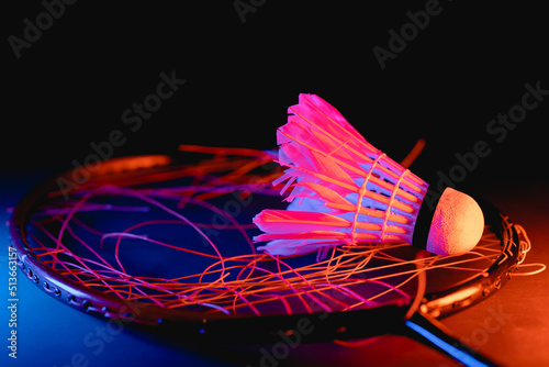 badminton shuttlecock with badminton racket breaking strings on court rubber floor. photo