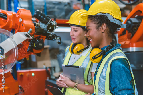 Women engineer worker working team helping together at work in modern advance machine factory.