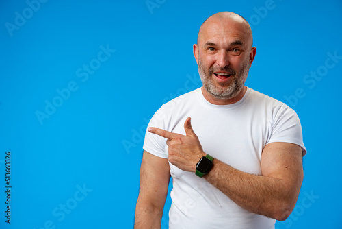 Handsome middle age mature man pointing to copy space