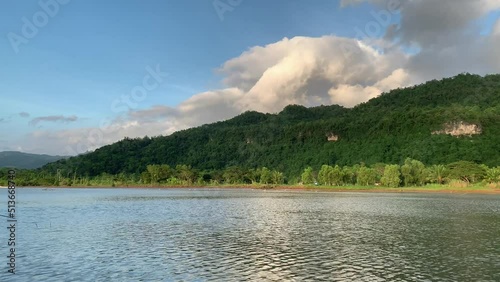 The landscape of the Grindulu river with mountains and clouds sky in the background in Pacitan, Indonesia. photo